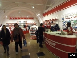 两名中国顾客购买索契奥运纪念品后走出莫斯科的一家体育运动服装店(美国之音白桦)