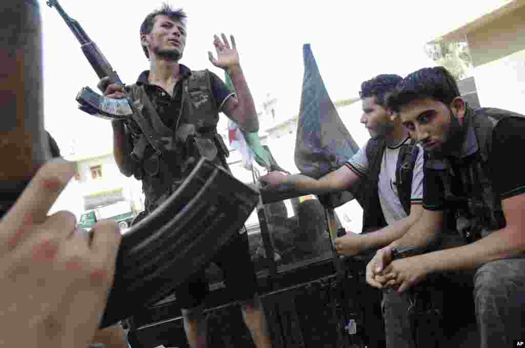 Syrian rebels sit in a pick up truck in Aleppo, Syria, July 28, 2012. 