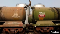 A worker walks atop a tanker wagon to check the freight level at an oil terminal on the outskirts of Kolkata, Nov. 27, 2013. 
