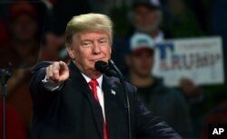 President Donald Trump points to a supporter of Alabama Republican Senate candidate Roy Moore as he speaks at a campaign-style rally at the Pensacola Bay Center, in Pensacola, Fla., Dec. 8, 2017.