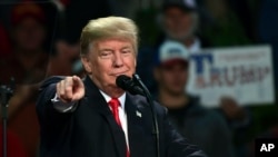 President Donald Trump points to a supporter of Alabama Republican Senate candidate Roy Moore as he speaks at a campaign-style rally at the Pensacola Bay Center, in Pensacola, Fla., Dec. 8, 2017.