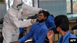 2020年10月1日衛生人員在巴基斯坦拉合爾為學生測試新冠病毒