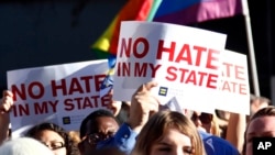FILE - Protesters call for Mississippi Governor Phil Bryant to veto a bill they say will allow discrimination against LGBT people, during a rally in Jackson, Mississippi, April 4, 2016. Louisiana Governor John Bel Edwards signed an anti-discrimination order Wednesday protecting the rights of gay and transgender people.