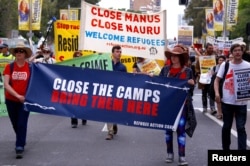 FILE - Refugee advocates protest in Sydney, Oct. 15, 2017, against the treatment of asylum seekers in detention centers in Nauru and on Manus Island.