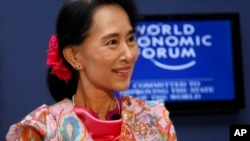Burma opposition leader Aung San Suu Kyi smiles during a debate with Myanmar President's Office Minister Soe Thane at the World Economic Forum on East Asia at Myanmar International Convention Center in Naypyitaw, June 6, 2013. 