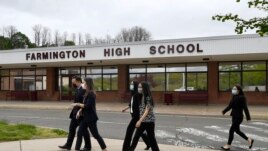 Connecticut Attorney General William Tong left, walks with teacher Clarissa Tan, second from left, and students from the Asian American Student Union after speaking at a program for Asian Pacific American Heritage Month at Farmington High School in Farmington, Conn on May 10, 2020. (AP Photos/Jessica Hill)