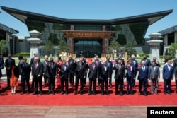 Leaders attending the Belt and Road Forum wave as they pose for a group photo at the Yanqi Lake venue on the outskirt of Beijing, China, May 15, 2017.