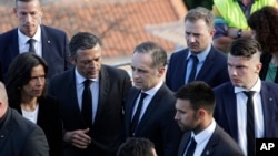 German Foreign Minister Heiko Maas, center, visits near the scene where a bus crashed in Canico, on Portugal's Madeira Island, April 18, 2019.