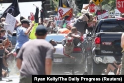 FILE - A vehicle plows into a group of protesters marching along 4th Street NE at the Downtown Mall in Charlottesville on the day of the Unite the Right rally, Aug. 12, 2017.