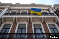 FILE - The Ukrainian national flag flies at half-staff at the Ukrainian Embassy in The Hague after the loss of a Malaysia Airlines plane over rebel-held territory in eastern Ukraine, July 18, 2014.
