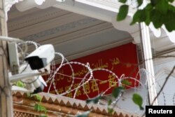 A propaganda banner and a security camera are placed on the walls of a mosque in the Old City in Kashgar, Xinjiang Uighur Autonomous Region, China, Sept. 6, 2018.