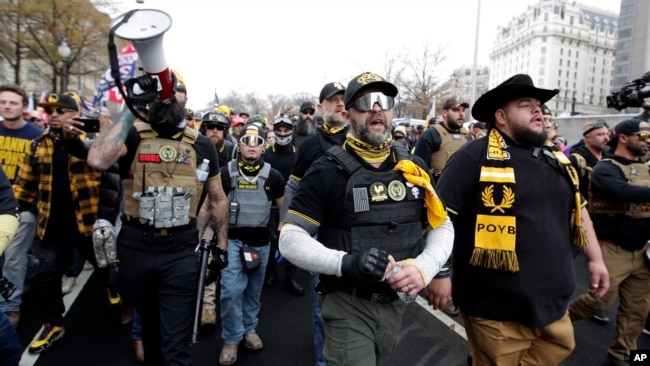 Supporters of President Donald Trump who are wearing attire associated with the Proud Boys attend a rally at Freedom Plaza, Saturday, Dec. 12, 2020, in Washington. (AP Photo/Luis M. Alvarez)