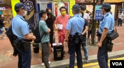 多名军装及便衣警员，截查摆街站反对当局收紧查册安排的工会成员 (美国之音/汤惠芸)