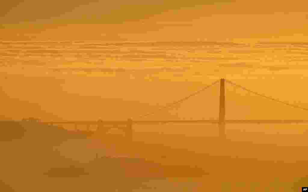 Kabut menyelimuti Golden Gate Bridge dan pulau Alcatraz saat matahari terbenam di Berkely, California, 28 Februari 2016.