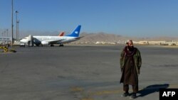 一名塔利班成员站在喀布尔机场的跑道上。(2021年12月8日)