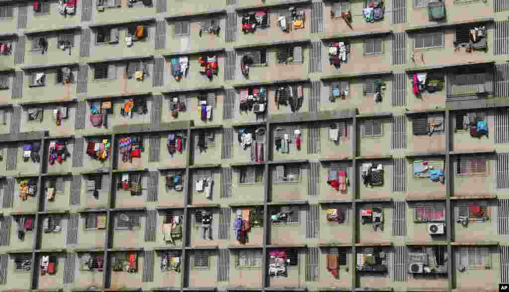 آویختن لباس&zwnj;ها برای خشک شدن از یک ساختمان مسکونی در بمبئی، هندوستان