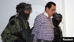 FILE - Soldiers escort head of the Beltran Leyva drug cartel Hector Beltran Leyva in Mexico City, in this handout picture taken Oct. 1, 2014 by the Attorney General's Office. 