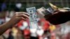 A gambler who lost a cockfighting bet, pays his wager inside an arena in Angeles city, north of Manila, Philippines March 11, 2015. 