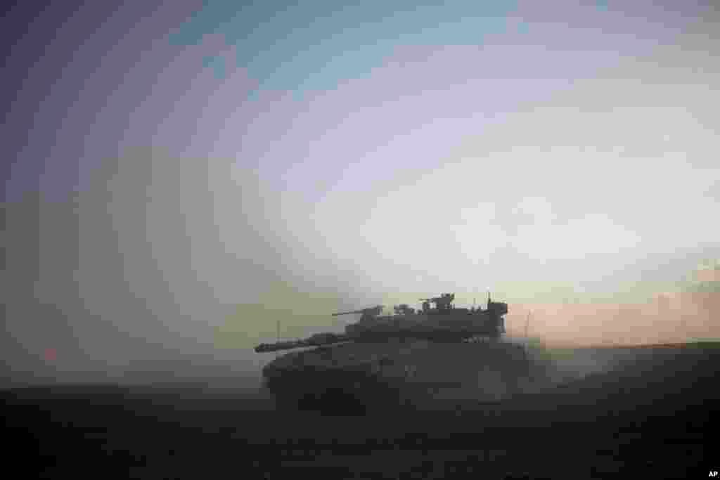An Israeli tank maneuvers to take a position along the Israel-Gaza Border,July 17, 2014.