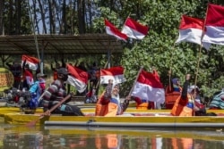 Aktivis Perempuan Pejuang Kali Surabaya melakukan upacara bendera di atas sungai sekaligus mengawali ekspedisi susur sungai. (Foto: Courtesy/Ecoton)