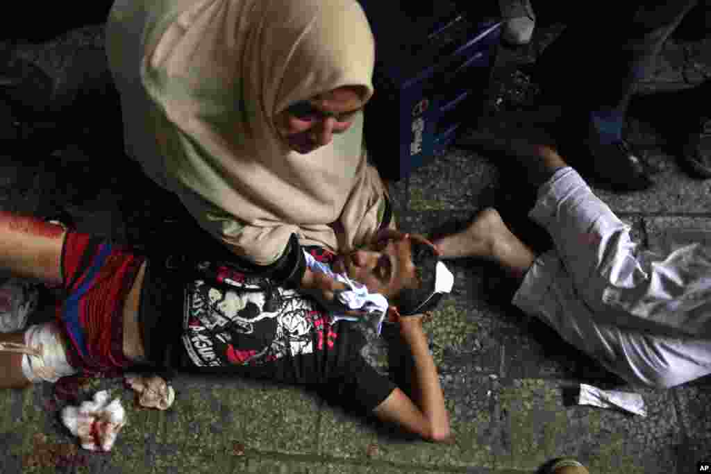 Egyptians lay on the ground after being injured during clashes between security forces and supporters of Egypt's ousted President Mohamed Morsi in Ramses Square, Cairo, August 16, 2013.