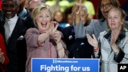 Flanked by supporters, Democratic presidential candidate Hillary Clinton, second from left, celebrates after winning the New York primary election, Tuesday night, April 19, 2016.