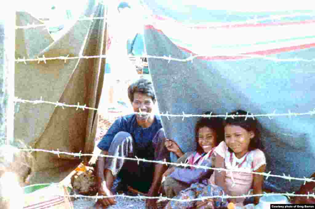 A Cambodian family gathered under a tarp in Sa Keo province, Thailand, in November, 1979.