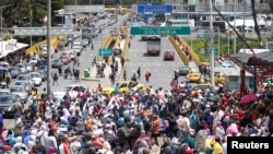 Migrantes venezolanos hacen cola para registrar su salida de Colombia antes de ingresar a Ecuador en el puente internacional Rumichaca, Colombia, el 9 de agosto de 2018.