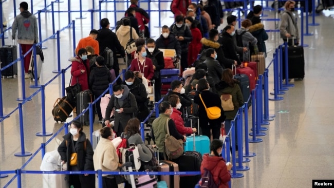 上海浦东国际机场内戴着口罩的旅客。(2020年1月27日)