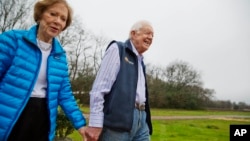 Former President Jimmy Carter, right, and his wife Rosalynn arrive for a ribbon cutting ceremony for a solar panel project on farmland he owns in their hometown of Plains, Georgia, Feb. 8, 2017. 