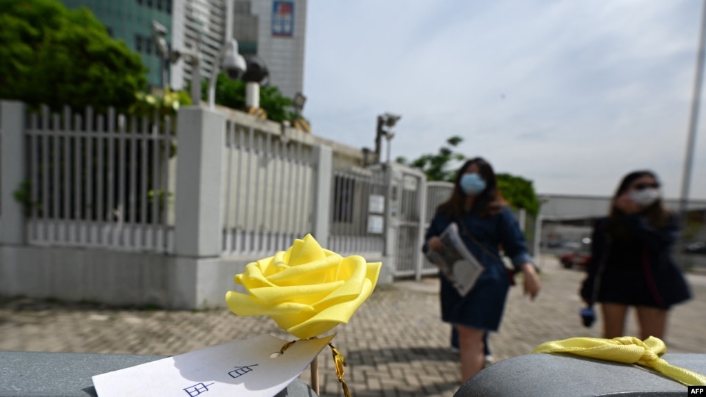 一枚系着“自由花”纸签的黄色玫瑰被摆放在香港苹果日报总部楼外。（2021年6月22日）