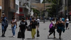 CARACAS – People wearing face masks walk along Sabana Grande Boulevard after the government intensify a nationwide lockdown as a preventive measure against the spread of the COVID-19 coronavirus, in Caracas, on July 15, 2020. Federico PARRA / AFP