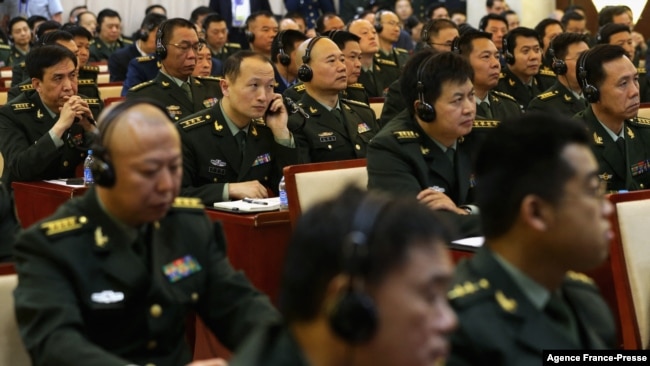 FILE - Students of the National Defense University listen as US Secretary of Defense Chuck Hagel gives a speech at the university in Beijing on April 8, 2014.