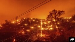 Seen in a long exposure photograph, embers burn along a hillside as the LNU Lightning Complex fires tear through unincorporated Napa County, Calif., on Tuesday, Aug. 18, 2020. Fire crews across the region scrambled to contain dozens of wildfires sparked b