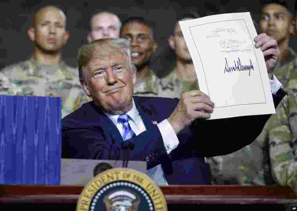 도널드 트럼프 대통령이 뉴욕주 포트 드럼의 미 육군 부대를 방문해 2019 회계연도 국방수권법안에 서명한 뒤 이를 들어보이고 있다.