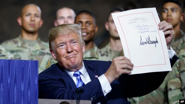 Tổng thống Hoa Kỳ Donald Trump ký ban hành Luật Chính sách Quốc phòng Mỹ tại một căn cứ quân sự của Hoa Kỳ ở New York hôm 13/8.