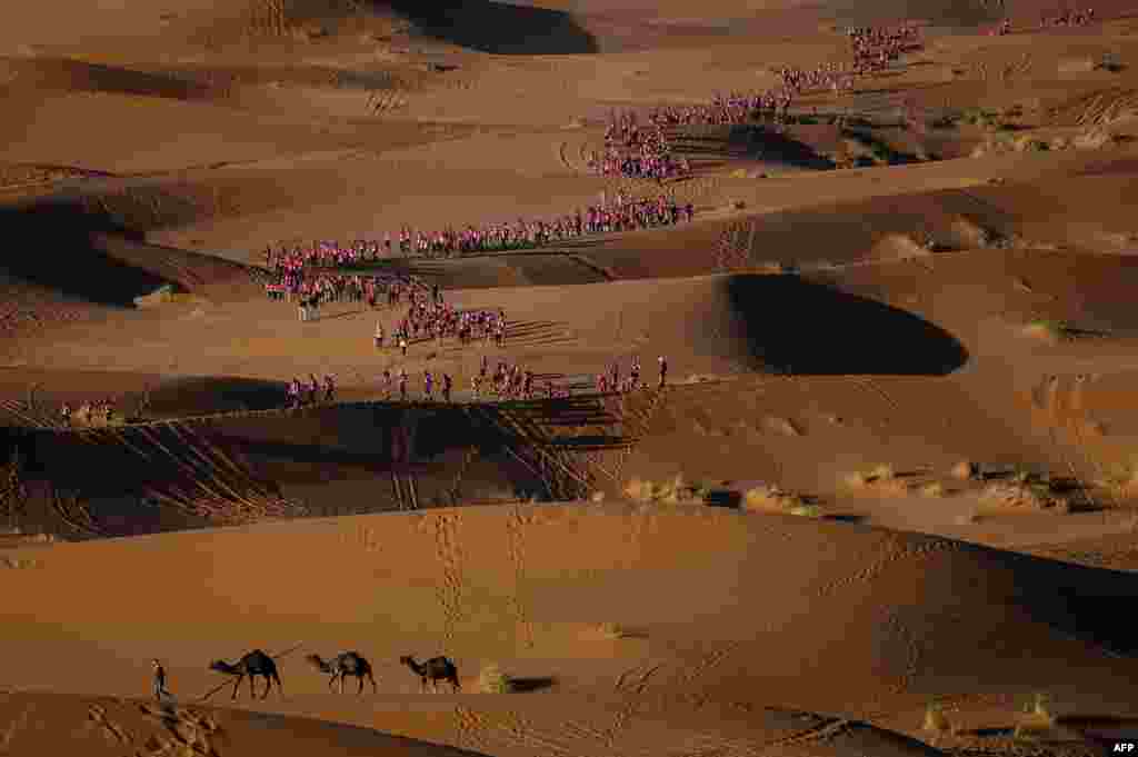 사막 트래킹 &#39;로즈 트립 모로코&#39; 에 참가한 여성들이 메르조가 부근 에르 그셰비에서 사막 위를 걷고 있다.