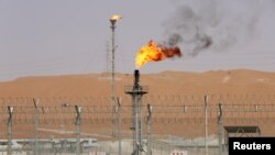 FILE - Flames are seen at the production facility of Saudi Aramco's Shaybah oilfield in the Empty Quarter, Saudi Arabia, May 22, 2018.