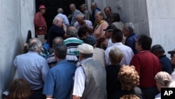 29일 그리스 항구도시 태살로니키에서 연금을 받으려는 사람들이 폐쇄한 은행 앞에 줄 서 있다.