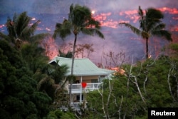Lava flows near a house on the outskirts of Pahoa during eruptions of the Kilauea volcano in Hawaii, May 19, 2018.