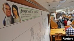 FILE - A genealogy chart of Joseph Smith hangs on a wall as people research records to work on their genealogy in the Family History Library of The Church of Jesus Christ of Latter-Day Saints on the campus of Brigham Young University in Provo, Feb. 16, 2012.