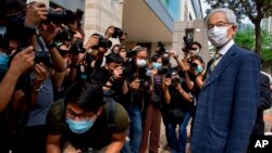 Pro-democracy lawmaker Martin Lee, right, arrives at a court in Hong Kong Thursday, April 1, 2021. (AP Photo/Vincent Yu)