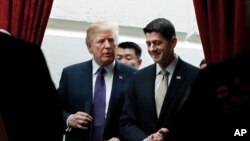 President Donald Trump, left, walks with House Speaker Paul Ryan of Wisconsin as they leave a meeting with House Republicans on Capitol Hill in Washington, Nov. 16, 2017.
