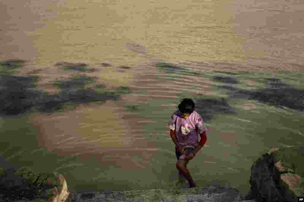 یک دختر هفت ساله که با خانوادش در قایقی زندگی&zwnj; می&zwnj;&zwnj;کند، پاهایش را در رود نیل می&zwnj;&zwnj;شورد. بعد از چند روز باران شدید، آب رود نیل رنگ قهوه&zwnj;ای تیره شده است.
