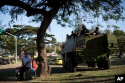 People watch an armored vehicle of Navy soldiers patrol near the Santos Dumont Airport in Rio de Janeiro, Brazil, July 28, 2017.