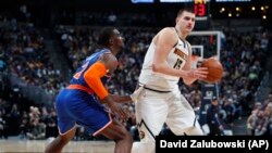 Nikola Jokić u duelu sa košarkašem Njujorka Noom Vonleom (Foto: AP/David Zalubowski)