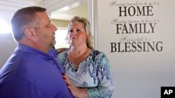 Laurie and Jason Holt look stand for a photo during an interview at their home, June 28, 2017, in Riverton, Utah. 