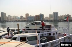 FILE - Used cars stand on a dhow at Port Khaled in Sharjah, UAE, April 5, 2018.