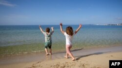 Dvoje dece na plaži u Španiji, posle ublažavanja oštrih mera uvedenih da bi se suzbilo širenje koronavirusa (Foto: AFP JAIME REINA)