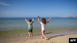 Dua anak-anak bermain di tepi pantai Portixol, Palma de Mallorca, di tengah pandemi Covid-19, 26 April 2020. (Foto: dok).